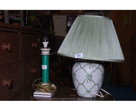 A pottery table lamp with ribbon and bow design plus another.