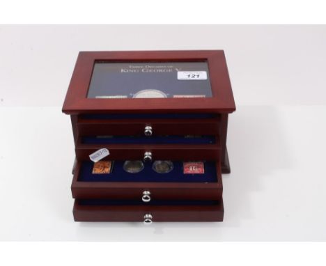 G.B. Three Decades of King George V – silver coins and postage stamps – to include Crown 1935 and others in four-drawer glass