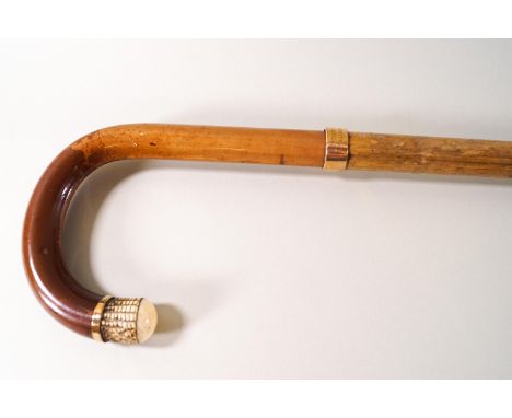 A bamboo shafted walking stick with brass mounts and ivory tip