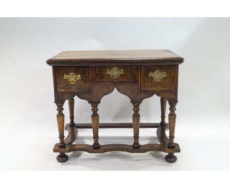 An early 18th century  walnut veneered on composite carcass low boy with plain rectangular top over three graduated frieze dr