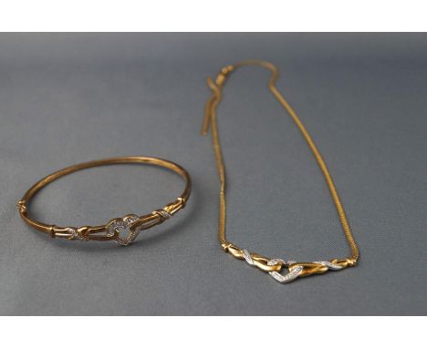 A yellow and white metal necklace and bangle stylized as a centrepiece with heart motif and illusion set diamonds. Hallmarked