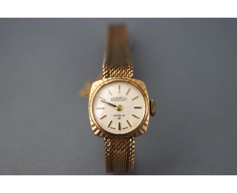 A 9ct gold ladies Roamer wristwatch. Manual wind movement. Integrated bracelet with ladder fold over clasp and safety chain. 