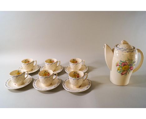 A Susie Cooper tea set, comprising teapot, six cups and saucers decorated with flowers within a blue dot and wave pattern