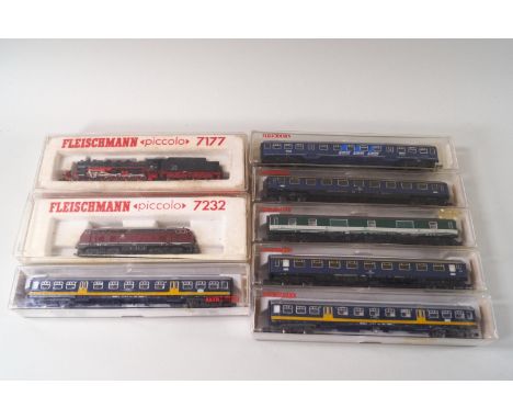 A collection of Fleischmann Piccolo N-gauge model railway, comprising a black and red locomotive and tender 7177, a maroon di