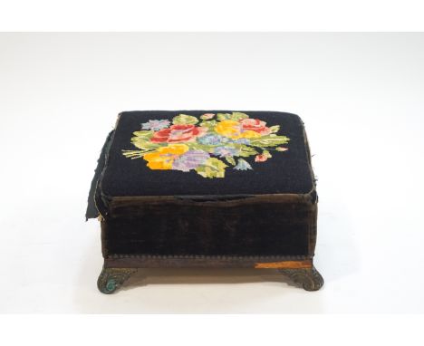 A Victorian footstool with tapestry top and brass scroll feet, 45cm square