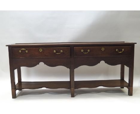 A George III oak dresser base with two drawers above a shaped apron, above a shaped shelf won square legs, 77cm high x 180cm 
