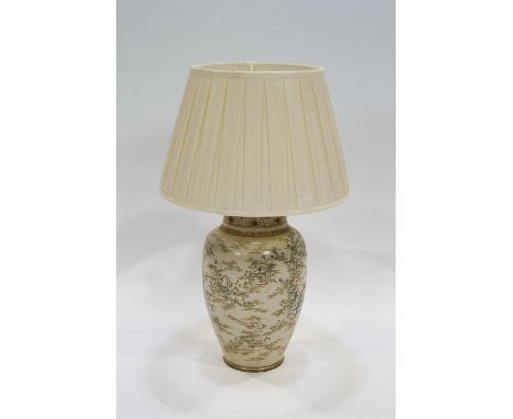 A Japanese earthenware vase mounted as table lamp with shade, painted with flowering plants on a cream ground, 66cm high incl