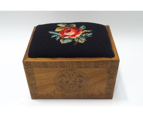 A teak stool with tapestry seat, the top hinged lid over storage compartment, 33cms high x 48cms wide x 35cm deep