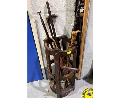 An oak Arts &amp; Crafts stick stand (requires restoration); a selection of wooden walking sticks