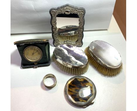 Two hallmarked silver back brushes; a white metal and tortoiseshell effect cased powder compact; and embossed silver photo fr