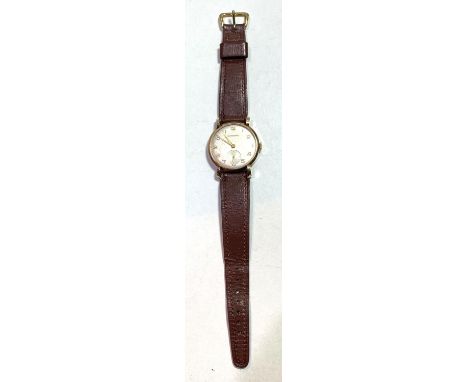 A gents vintage 9 carat Garrard wristwatch, on brown leather strap, inscribed