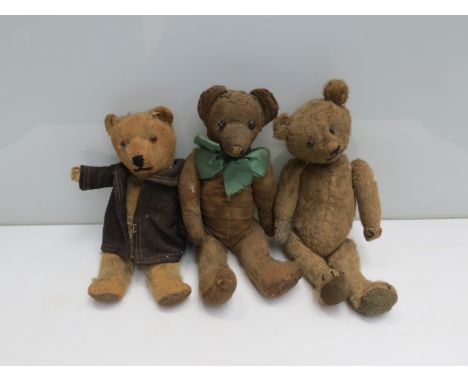 Three early teddy bears, one wearing green bow tie and another in jacket 