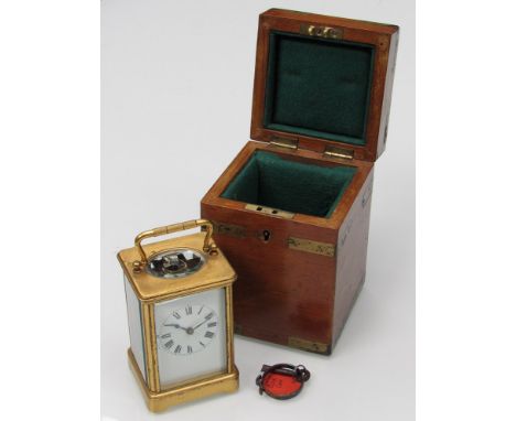 An early 20th Century French brass carriage clock with white enamel face, Roman numerials marked "made in Paris" with fitted 