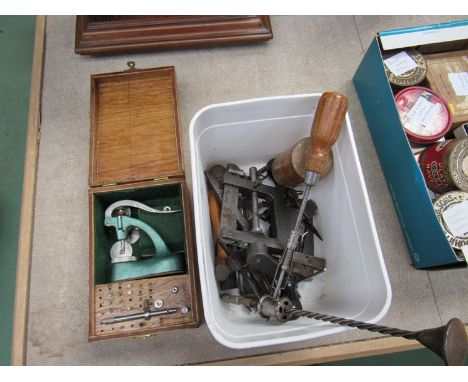 A tub of clock/watchmaker's tools including a mainspring winder and a cased jewelling set