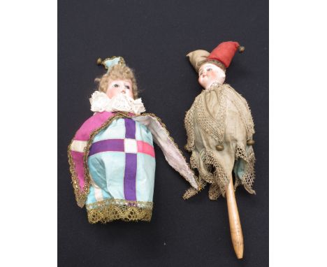 Two bulbous shaped bisque headed musical girl dolls dressed as Jesters a/f