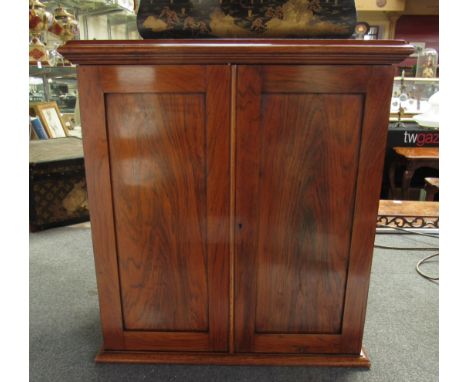 Circa 1860 a rosewood table top cabinet the two doors opening to reveal a single drawer and shelf with key 