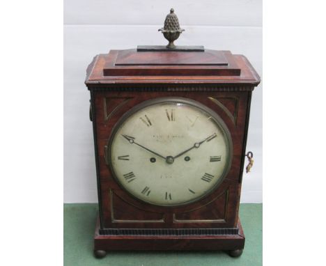 A Regency mahogany bracket clock with brass acorn finial, bezel, inlay, pierced side frets, ring handles and bun feet, painte