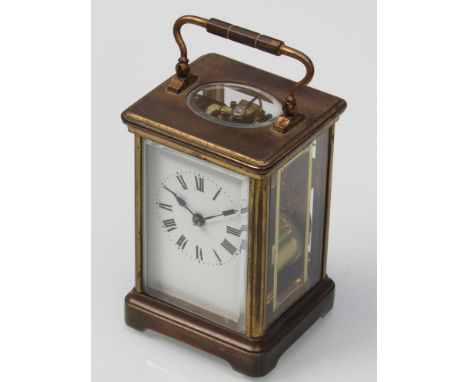 An early 20th Century French brass striking carraige clock with white enamel face, Roman numerals, 11.5cm high (excluding han