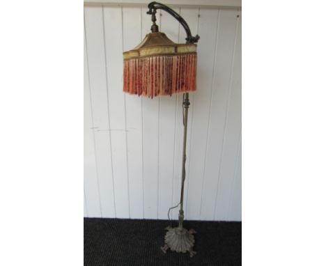 A late 19th Century standard lamp with arched top, tasselled and beaded shade