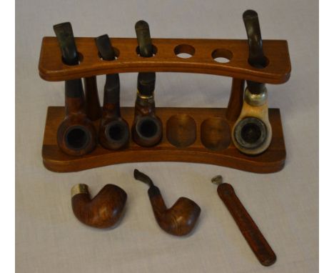 Pipe stand and pipes, one with a silver collar (AF)