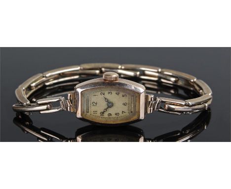 9 carat ladies gold wristwatch, the shaped rectangular dial with Arabic hours, manual wound, 9 carat gold on silver strap, ca