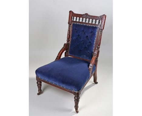 Victorian nursing chair, the carved top rail above a finial gallery and a button back, stuff over seat raised on turned legs