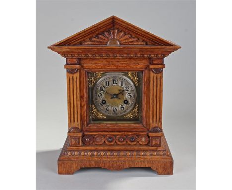 Early 20th Century oak cased mantel clock, the arched top with sunburst panel, flat columns and arched base, the silvered dia