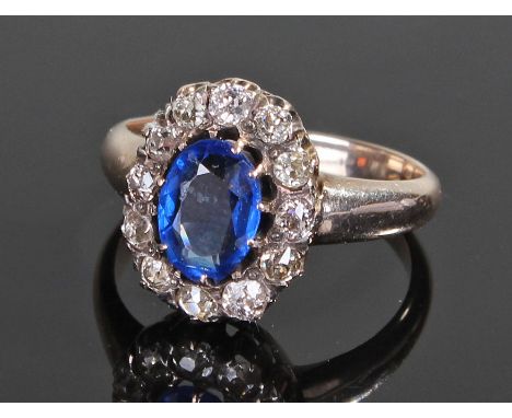 White metal diamond and sapphire, the central sapphire surrounded by twelve diamonds, ring size O