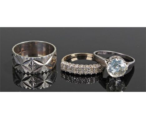 Three 9 carat gold rings, to include a 9 carat gold wedding band at 4.8 grams, a 9 carat gold ring with cubic zirconia and a 