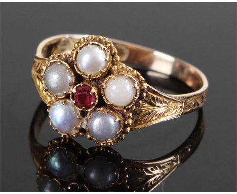 Victorian 12 carat gold pearl and ruby ring, the central ruby with five pearls to the border with an engraved shank, ring siz