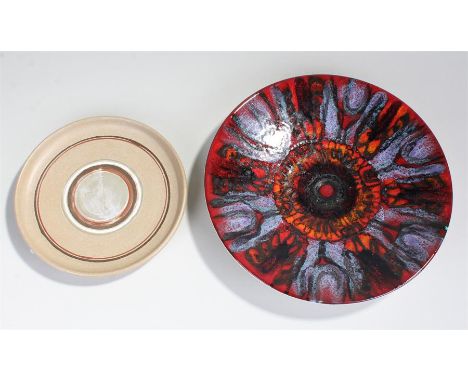 Poole Pottery "Delphis" plate, decorated with mottled shades of red, orange and blue with stylised designs (27cm in diameter)