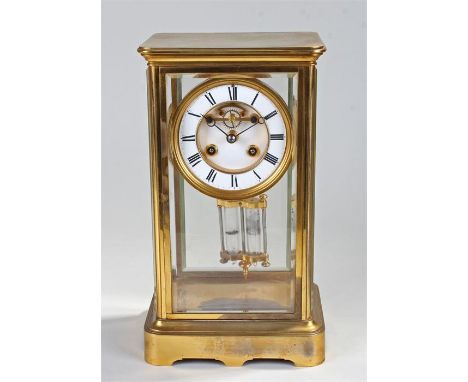 Early 20th Century brass, four glass, eight day mantel clock, the four bevelled glazed case with gilt brass top and base, the