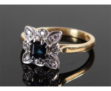 18 carat gold sapphire and diamond ring, the sapphire set in a flower head diamond surround, ring size N