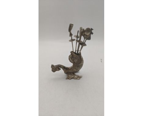 An Egyptian white metal cocktail stick holder in the form of a dolphin along with a set of six cocktail stick A/F, total weig