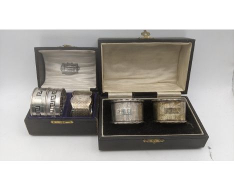 Silver napkin rings to include a pair having engine turned decoration and engraved initials, hallmarked 1920 in a fitted dome