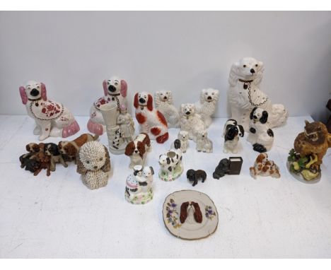 A collection of ceramic dog figures to include several Staffordshire style examples, a Beswick King Charles spaniel figure an