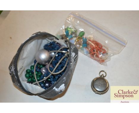 A purse and contents of various costume jewellery, bead necklaces, a white metal cased compass etc.