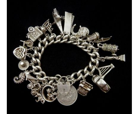 Silver charm bracelet, charms including car, Punch and Judy show, top hat, seahorse, cheque book, typewriter, Statue of liber