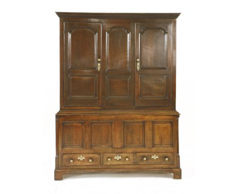 A George III oak hanging cupboard, having two double panelled doors flanking conforming central panels over four fielded pane