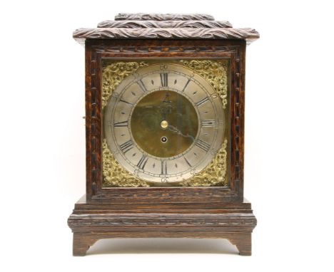 A carved oak cased mantel clock, with brass dial and single fusee movement, 47cm high