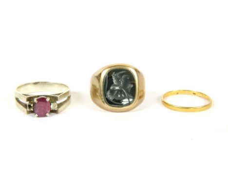 A gentlemen's 9ct gold hematite intaglio signet ring, 7.34g, a 22ct gold wedding ring, 1.15g, a white gold three stone ruby a