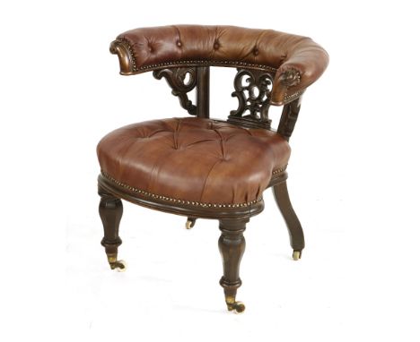 An early Victorian mahogany and leather button upholstered chair, with an horseshoe back over a shaped seat, on faceted balus