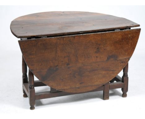 An 18th Century oval oak gateleg dining table
The oval top with two hinged flaps raised upon four ring turned baluster suppor