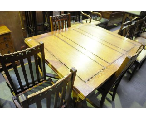 An Early 20th century Gillows oak draw leaf dining table on ring turned supports with an " X " shaped cross stretcher and bal
