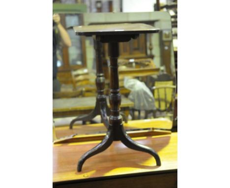 An Early 19th century mahogany wine table, the square top raised on a ring turned baluster shaft and 3 downswept supports.