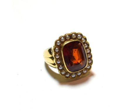 An 18 carat gold hessonite garnet and seed pearl cluster ring, the cushion cut hessonite garnet in a yellow millegrain settin