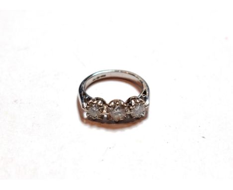 A platinum diamond three stone ring, the graduated round brilliant cut diamonds in claw settings, on a tapered shoulder plain