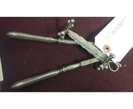 A pair of continental silver knife rests together with a French nut cracker