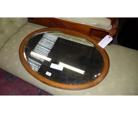 An oak oval mirror with bevelled plate