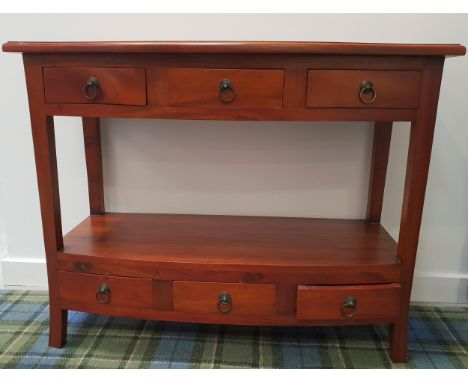 BOW FRONT TEAK SIDE TABLEwith a moulded top above three frieze drawers, with a lower shelf and three drawers, standing on sha